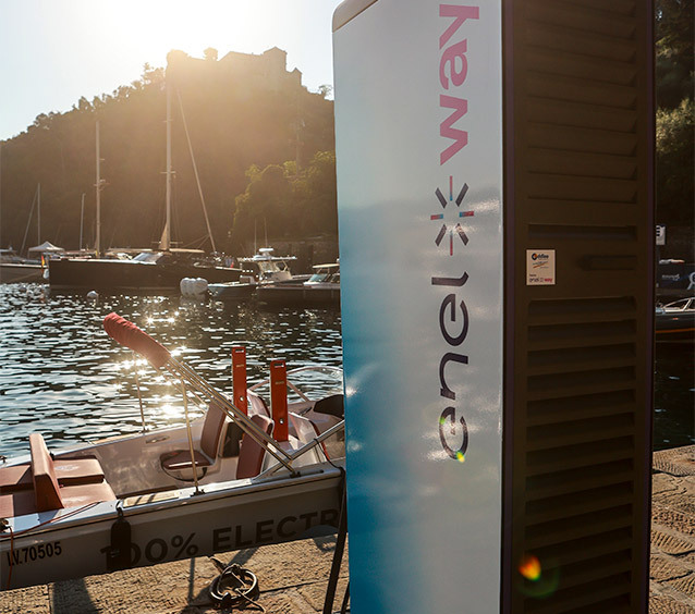 Barca elettrica attraccata a Portofino con infrastruttura di ricarica in primo piano